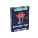 Spaceteam: Triangulum Expansion game box featuring a dark blue space-themed design with an orange geometric spaceship logo and green expansion banner at the top. The box displays the Spaceteam title in bold white letters with "A Chaotic and Cooperative Card Game" tagline underneath. The minimalist cosmic artwork includes scattered stars and planets against the navy background, with player count and age information shown at the bottom.