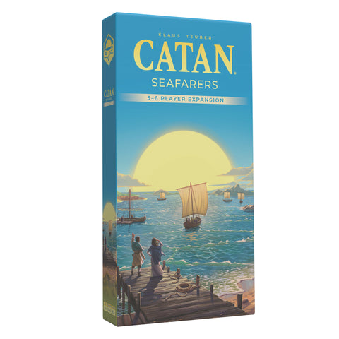 Box of Catan Seafarers 5-6 Player Expansion, featuring a blue box with the Catan logo in yellow and several sailing ships on a blue ocean. The box cover artwork shows people watching from a wooden dock as ships with white sails navigate the waters, with a large sun setting on the horizon.