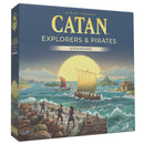 Board game expansion box for 'Catan: Explorers & Pirates' with a sailboat and dock scene on turbulent ocean background. 