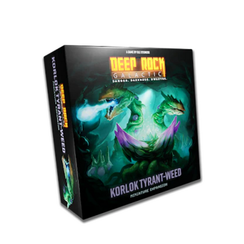 Deep Rock Galactic board game expansion box featuring the Korlok Tyrant-Weed, displaying dark packaging with dramatic green and purple alien plant creature artwork. The box shows a menacing, tentacled vegetation monster with glowing effects against a dark underground cave environment. The product packaging includes the Deep Rock Galactic logo and "Korlok Tyrant-Weed" title prominently displayed on the front.