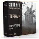 Box packaging for the S.T.A.L.K.E.R. The Board Game 'Terrain Miniature Pack' expansion, featuring a black box design with white text and an atmospheric black and white image of a dilapidated windmill in a foggy landscape.