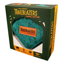The box for "Trailblazers Travel Edition" by Ryan Courtney, showing a green packaging with yellow text and outdoor-themed graphics. Inside the window display is a teal zippered carrying pouch with an orange patch bearing the game logo.