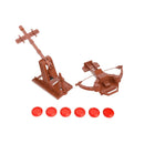 Crossbows & Catapults Weapons Cache expansion showing a brown plastic ballista and trebuchet with six red disc projectiles. The ballista features a crossbow-style design with a firing mechanism, while the trebuchet has a counterweight arm system for launching ammunition.