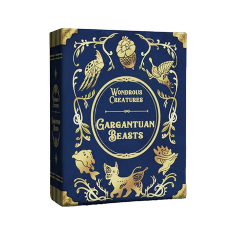 Wondrous Creatures: Gargantuan Beasts board game expansion box featuring ornate blue and gold fantasy artwork. The decorative cover displays mythical creatures arranged around an elegant central title frame. The Victorian-style design uses rich navy blue background with intricate golden illustrations and ornamental corner details.
