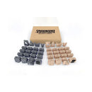 Crossbows & Catapults Builder's Bounty expansion set showing 42 modular castle pieces arranged in organized rows. The set includes gray and tan colored building components like bricks, foundations, turrets, towers, spires, balconies, stairs, and prison gates spread out next to the product box.