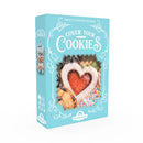 The box displays various cookies visible through a window, including a heart-shaped cookie with red filling, a chocolate chip cookie, and a sprinkled cookie. Cover Your Cookies box in teal blue packaging from Grandpa Beck's Games, featuring a 'Sweetly Frosted Revenge' tagline.