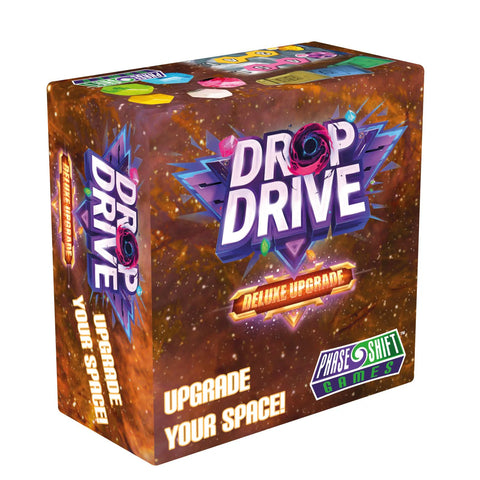 Drop Drive Deluxe Upgrade board game box featuring vibrant space-themed artwork with swirling galaxy colors in orange, purple, and blue tones. The box displays the game title prominently in white letters with a cosmic design, along with "Deluxe Upgrade" and "Phase Shift Games" branding. The packaging showcases a starfield background with geometric crystal-like elements, emphasizing the space exploration theme of this board game enhancement set.