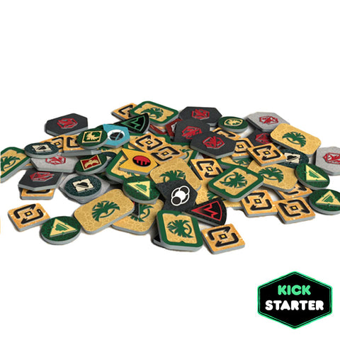 Dune: War for Arrakis Plastic Token Set showing a scattered collection of 77 colorful engraved plastic game tokens. The tokens feature various shapes including hexagons, squares, and circles in green, tan, black, and gray colors with faction symbols and game icons. 