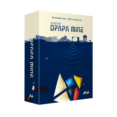 Orapa Mine board game box featuring a distinctive split-level design with an industrial mining landscape above ground and underground mining elements below. The top half shows a cream-colored surface with mining buildings, equipment, and infrastructure silhouettes, while the bottom half displays a deep blue underground section containing colorful geometric tangram pieces representing minerals. The box spine shows the game title vertically in white text against the blue background.