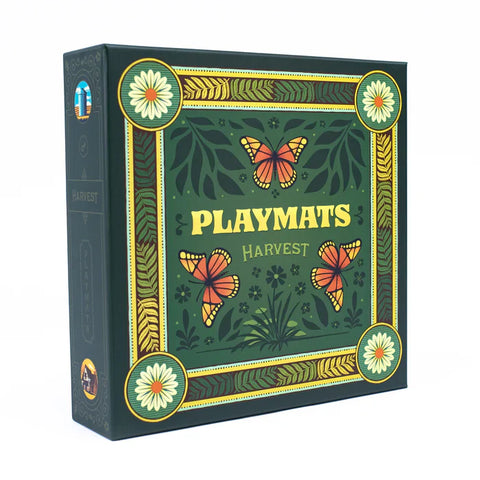 Playmats Harvest board game box featuring an ornate green design with decorative golden borders, floral corner medallions, and orange monarch butterflies scattered across a botanical background. The box displays "PLAYMATS" in large yellow lettering with "HARVEST" beneath it, all framed by an elegant Art Nouveau-style border with leaf and wheat motifs. 