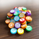 Colorful game pieces with symbols on a wooden surface